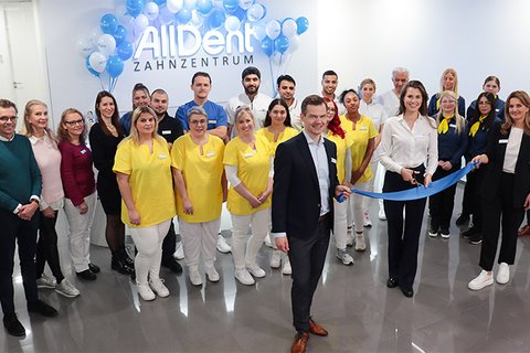 Geschäftsleitung mit Eröffnungsband und dem Team im Zahnzentrum Karlsruhe